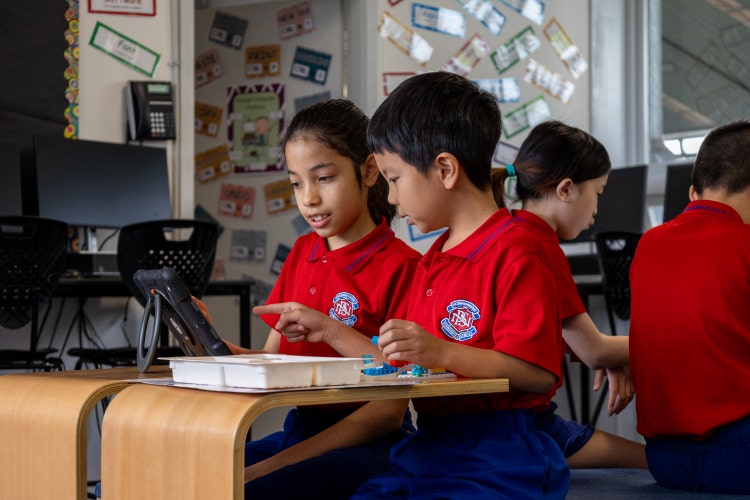 Two students working collaboratively on a robotics task.