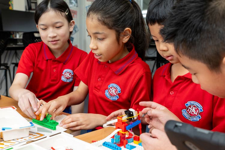 A group of students working with lego and iPads to complete robotics activities.