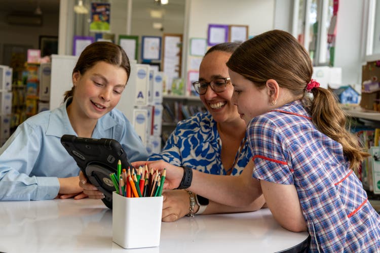 Two Normanhurst Public School students and a teacher working on an iPad.