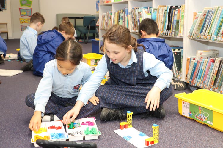 Two students working together on a robotics project using Lego Spike.